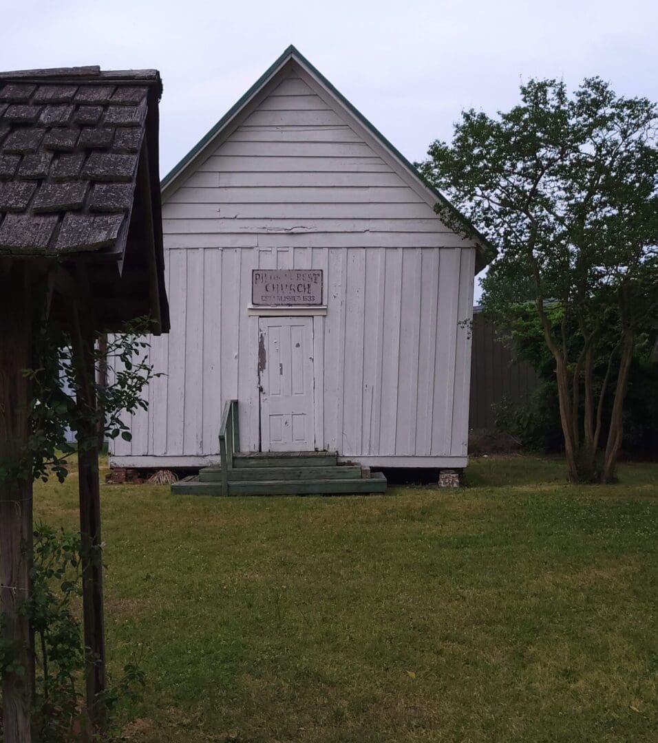 A white church with a wooden door and roof.