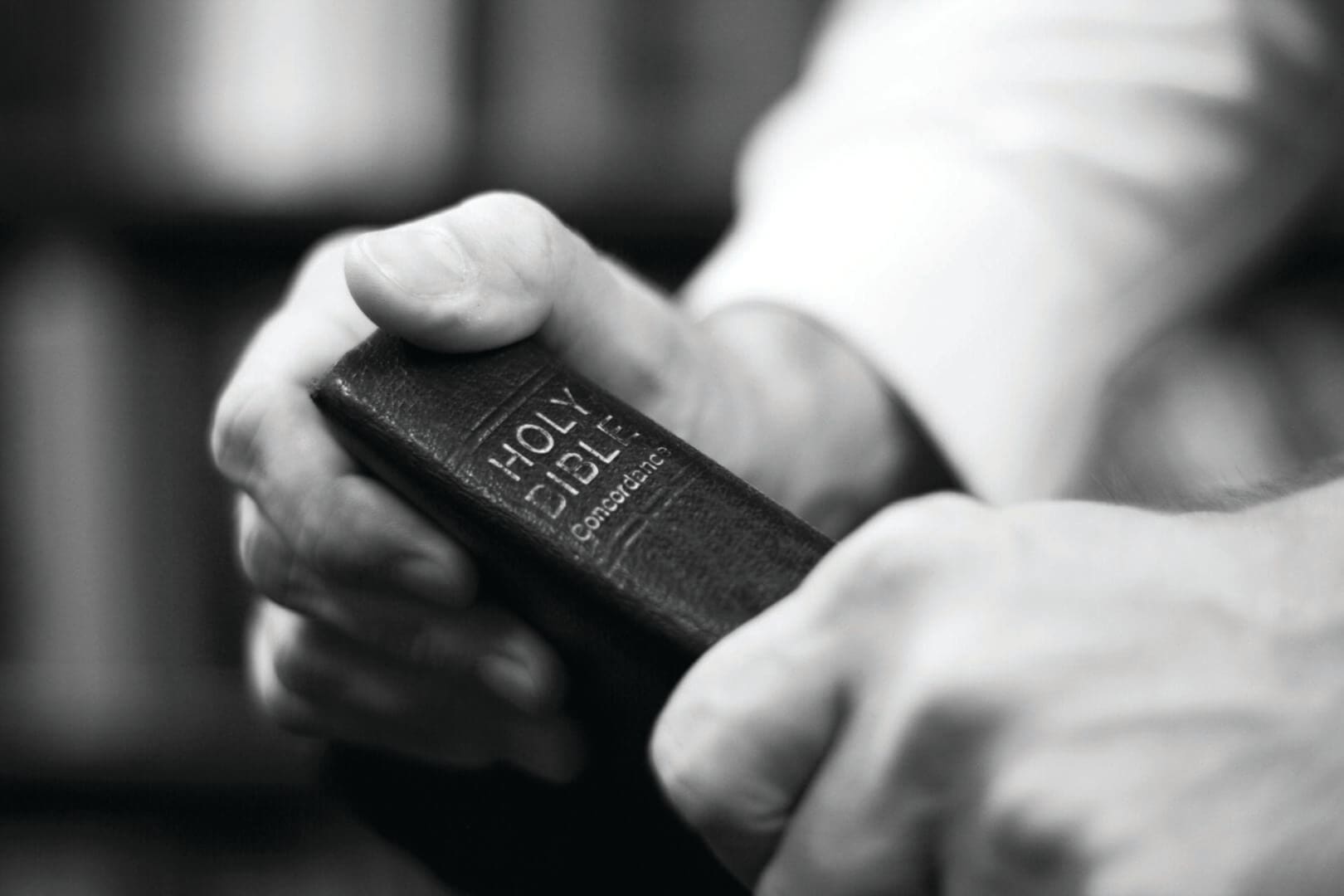 A person holding an old bible in their hands.